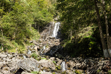 Waterfall on the way to Lake Ritsa - it is also called milky. Milky is one of the most beautiful waterfalls in the Caucasus. Autumn sunny day.