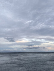 The sky is cloudy and the ocean is calm, Calm ocean waves rolling onto sandy beach under cloudy sky scenic view from above nature landscape seascape coastal scene