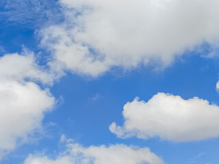 Cumulus clouds in the sky are abstract and aesthetic, with a blue sky background. Cumulus clouds are white clouds that have a flat base that look very soft and fluffy
