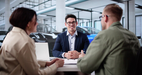 Happy Hispanic Salesman Passing Car Keys To New Customers