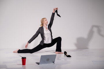 Barefoot ballerina dancing in business suit on white background. 