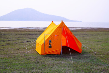 Orange tent with lake view and sunset