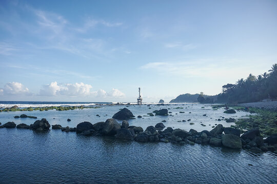 Beacon Tower in the Middle of the Sea with Waves and Clouds at pidakan beach pacitan east java indonesia
