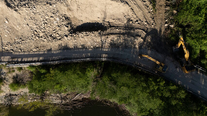 Top-down drone shot of Vernasca SP21 at Mignano Dam shows landslide debris covering the road with...