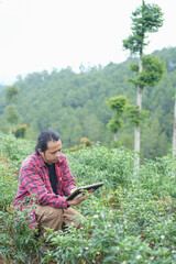 Tech savvy farmer crouched in chili field, combining hands on plant inspection with real time digital monitoring symbol of future forward agriculture
