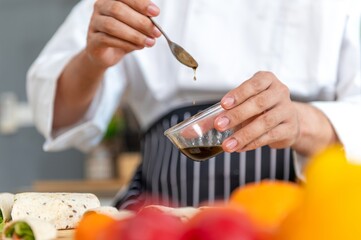 Chef is pouring a sauce into a bowl