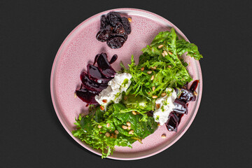 A delicate beetroot salad arranged on a soft pink ceramic plate, featuring slices of baked...