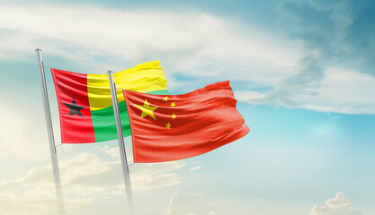 Guinea-Bissau China friendship flags are waving in the sky. Two country flag for agreement or deal....
