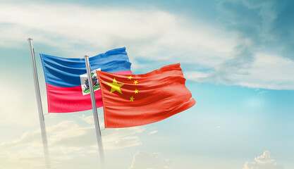 Haiti China friendship flags are waving in the sky. Two country flag for agreement or deal....