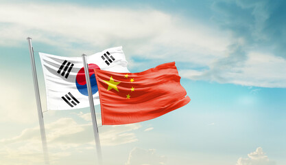 Fototapeta premium South Korea China friendship flags are waving in the sky. Two country flag for agreement or deal. Korean China national flag for commitment.