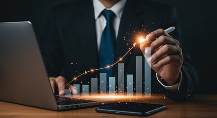 Businessman analyzing growth chart with laptop and stylus on desk in dark background setting indoors