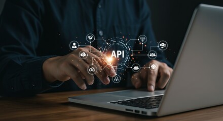 A person using a laptop with an api graphic overlay showing cloud computing and digital connections