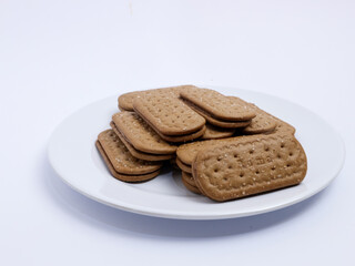 Stack of rectangular biscuits with sugar topping neatly arranged on a white plate, isolated on a white background