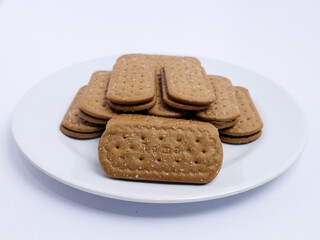 Stack of rectangular biscuits with sugar topping neatly arranged on a white plate, isolated on a white background
