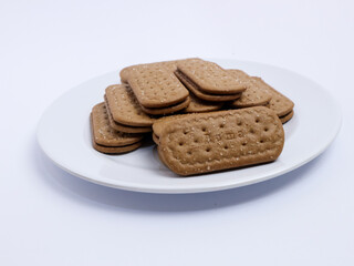 Stack of rectangular biscuits with sugar topping neatly arranged on a white plate, isolated on a white background