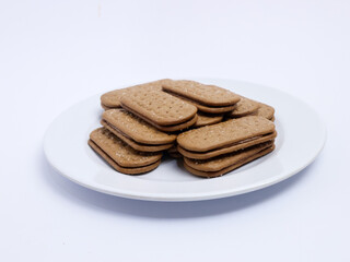 Stack of rectangular biscuits with sugar topping neatly arranged on a white plate, isolated on a white background