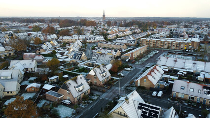 Aerial shot of houses with solar panels snow on roof during winter. Street in a residential area...