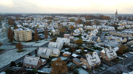 Aerial shot of houses with solar panels snow on roof during winter. Street in a residential area...