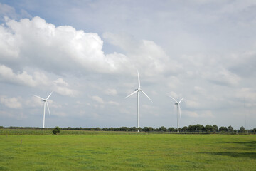 Landscape photo of row of wind turbines in meadow field. Green renewable energy, global warming,...