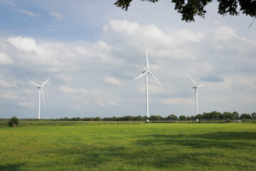 Landscape photo of row of wind turbines in meadow field. Green renewable energy, global warming, sustainability concept. 