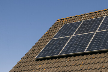Solar panels on roof, side view. Green clean energy, sustainability, eco-friendly technology powered by the sun. Renewable energy solutions building house neighborhood.