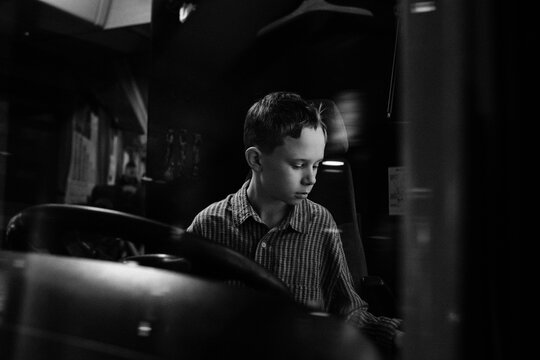 boy sitting on a bus pretending to drive