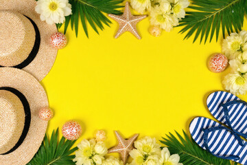 straw hat flip flops starfish seashells and flowers on a yellow background