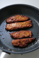 Chicken frying pan. Fresh juicy fried meat in a row dinner prepared dish meal cooking grease grilling. 