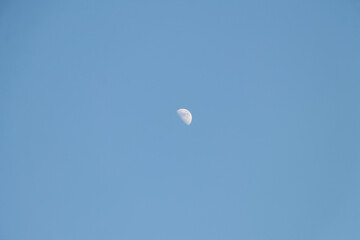 Moon crescent blue sky. Black and white half moon photography, horizontal photo.