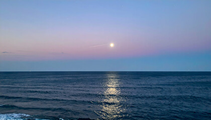 Obraz premium Serene Ocean Sunset with Moon and Pink Sky