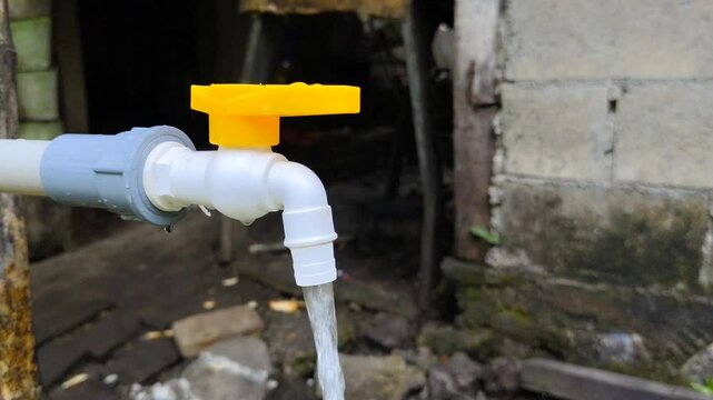 close up of clear water coming out of a water faucet outdoors
