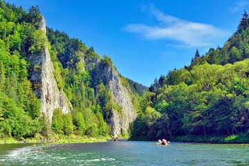 Rafting on the Dunajec river in the Pieniny National Park at summer sunny day. It is a popular tourist attraction in Pieniny mountains, Poland
