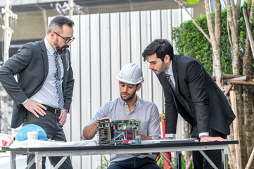 Two Businessman and power engineering talking and checking quality power solar cell with laptop computor on site new project power solution business