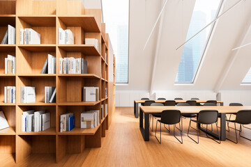 Fototapeta premium Modern library interior with wooden bookshelves, large slanted windows, and minimalist tables and chairs in bright natural lighting. 3D Rendering