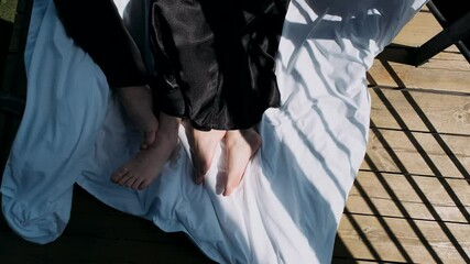 the feet of a young couple lie on a blanket