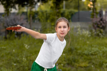 Portrait of teenage girl playing table tennis, tennis, yellow ball with racket, outdoor sport...