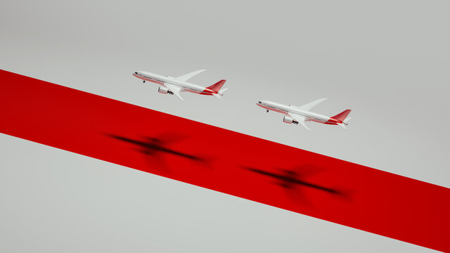 Two commercial airplanes flying over a red runway during daytime