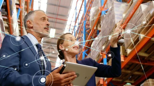 Logistics managers pointing at shelving and swiping tablet while starting animated tracking overlay