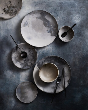 Top view of an elegant set of ceramic tableware on textured surface