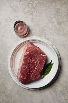 Raw beef steak with herbs on ceramic plate