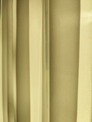 Obraz premium Net Curtain Background. Light, translucent yellow curtain on window is illuminated by sun. Full frame. Copy space. Close-up.