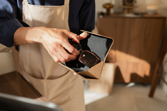 Store employee handling sunglasses in a modern bag shop