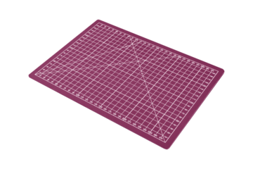 Pink cutting mat with white grid and diagonal lines is isolated. Angled view from side.