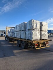 Concrete Paving Slabs Secured in Film Wrap on Trailer Under a Clear Blue Sky During Daytime Transport