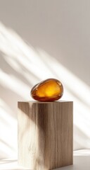 Obraz premium Amber gemstone on light wood cube, sunlit