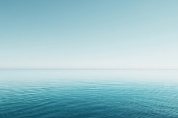 Obraz premium A serene, still expanse of blue water under a clear, pale sky