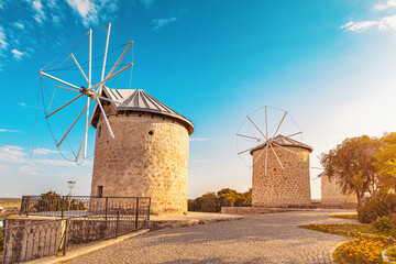 Historic windmills under blue sky during golden hour in Alacati, a popular Aegean town on the Cesme peninsula, Turkiye