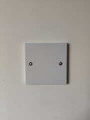 Close-up of a White Square Electrical Outlet Cover Plate on a Lightly Textured Wall