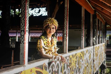 a beautiful asian woman wearing red king bibinge clothes in dayak traditional house