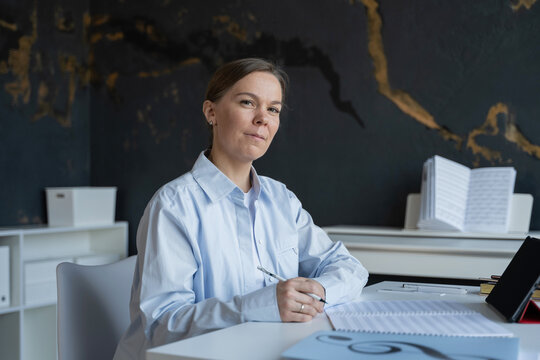 Woman preparing for piano lesson with music sheets